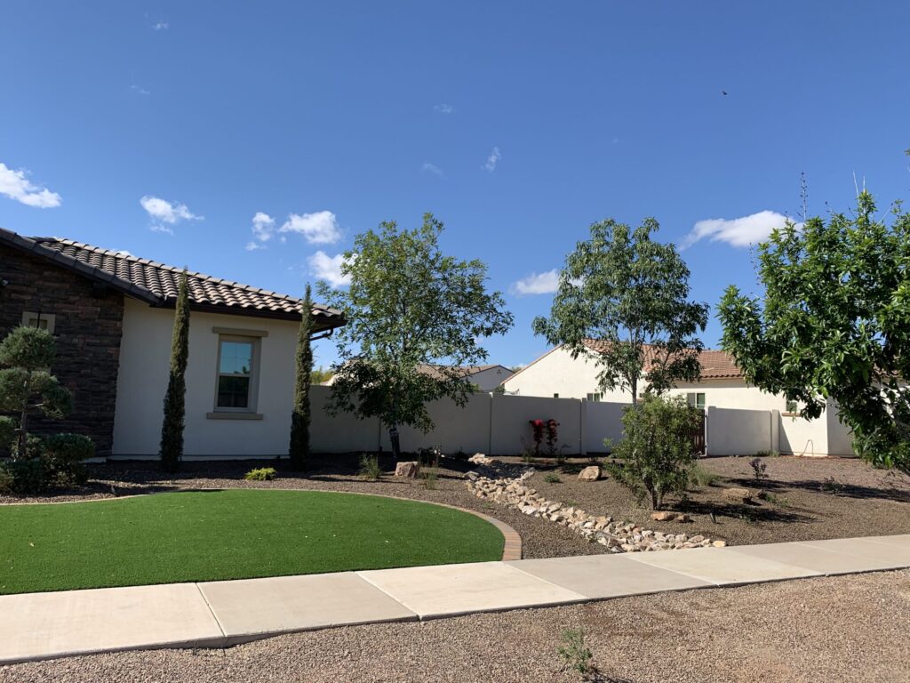 Residential landscape design featuring artificial turf and diverse plantings in a Phoenix, AZ yard, showcasing professional landscaping services by Core Landscape.