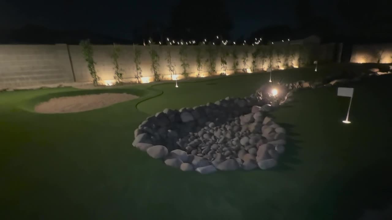 Night walkthrough of the lit water feature and green